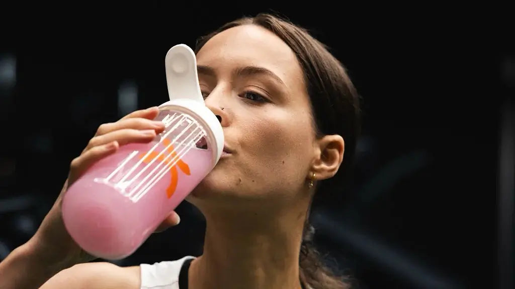 A woman drinking a bottle of MOVE Fresh Berries flavor