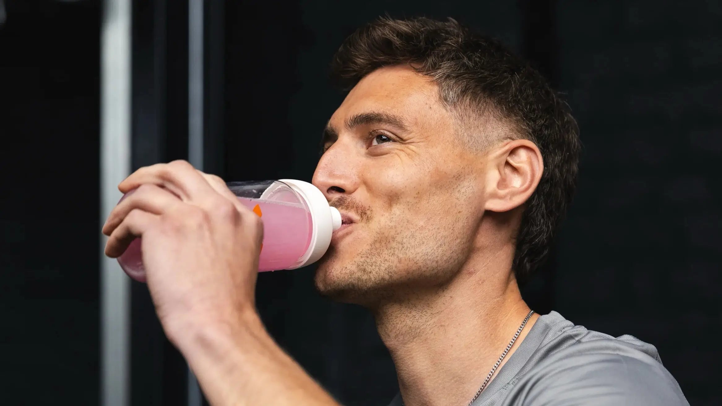 A guy drinking a bottle of MOVE Fresh Berries flavor